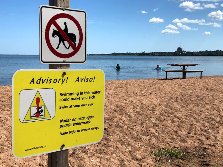 A sign warns of the risks of swimming at Lake Superior’s Maslowski Beach in Ashland, Wis., on Aug. 10, 2019. Researchers have flagged high levels of E. coli at the beach and others along Wisconsin’s Great Lakes shoreline. The bacteria arrive in human, bird and animal feces, and can sicken people who ingest them. Danielle Kaeding/WPR