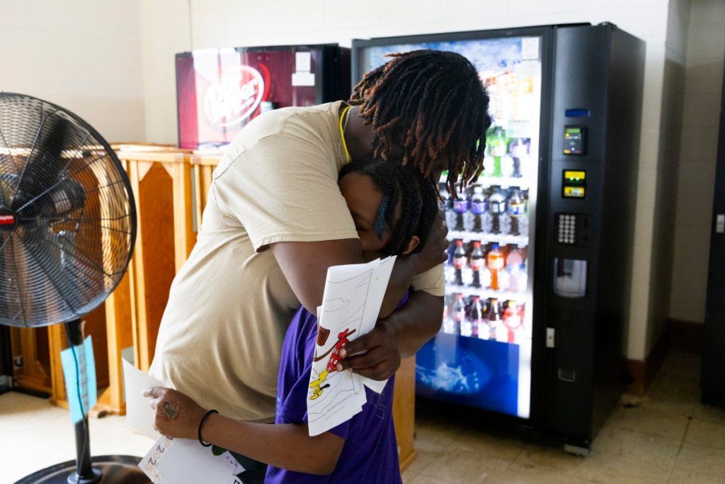 Deloise L. hugs her son goodbye during Camp Reunite at Taycheedah Correctional Institution. (Joe Timmerman / Wisconsin Watch)