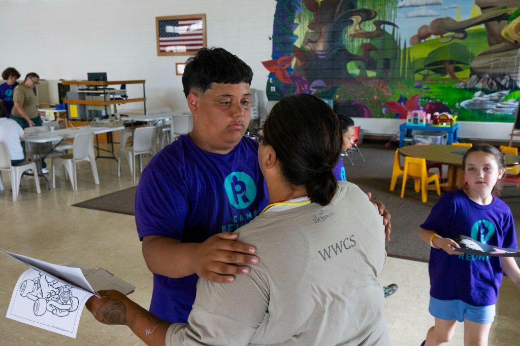 Nyzaiah hugs his mother Alba P. goodbye during Camp Reunite at Taycheedah Correctional Institution, June 24, 2025, in Fond du Lac, Wis. “Me and my mom are really close,” he says. (Joe Timmerman / Wisconsin Watch)