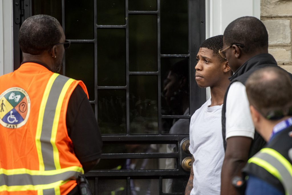 Milwaukee resident Da-Lin Anderson is greeted on Tuesday, Aug. 12, 2025 at his Milwaukee, Wis. home by officials offering support following flooding throughout the area days before. Angela Major/WPR