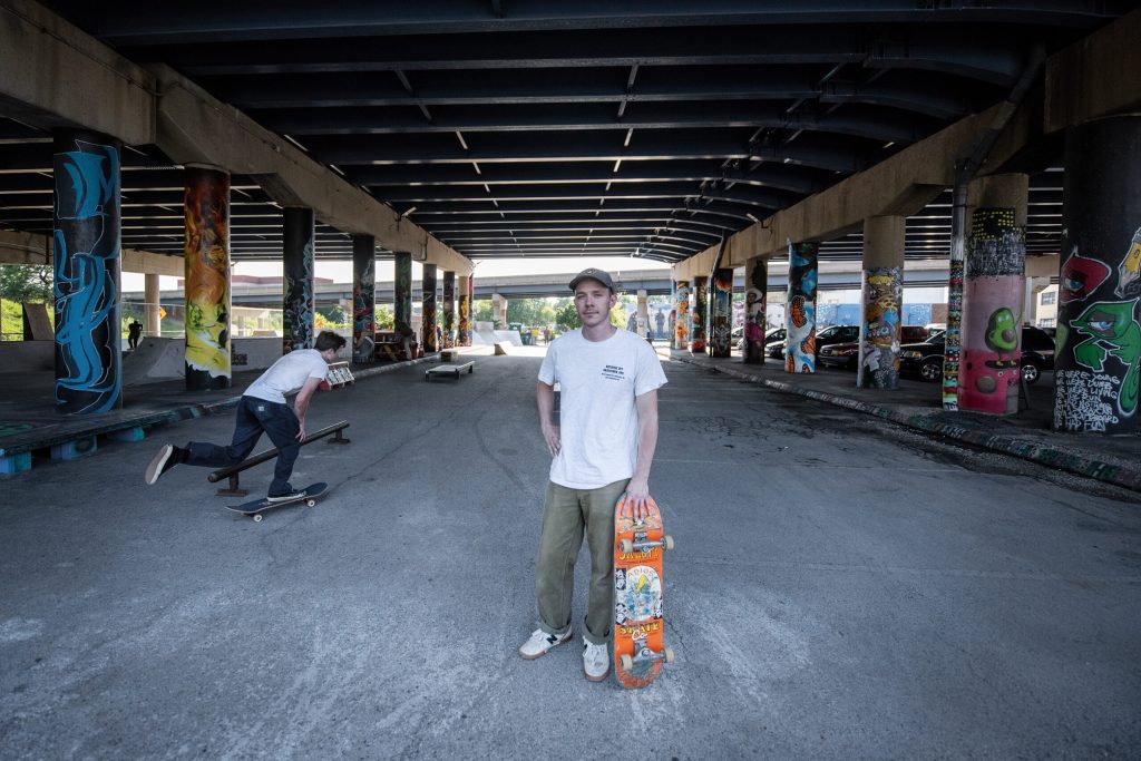 Dylan Shanahan stands in between the artwork and skatepark equipment at National DIY Skatepark on Wednesday, Aug. 13, 2025, in Milwaukee, Wis. Angela Major/WPR