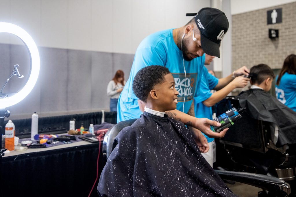 Trevor Jones with Region Cuts lets student Donovan Davis Jr. pick out hair products to finish up his cut Sunday, Aug. 24, 2025, during the JP Hair Design’s Back 2 School Free Haircutz event at the Alliant Energy Center in Madison, Wis. Angela Major/WPR