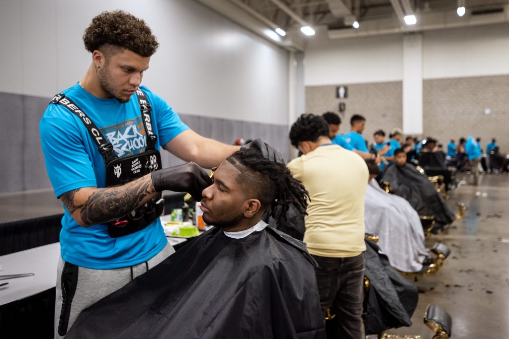 Bishop Beasley with Headquarters Madison gives student As-Sidq a haircut Sunday, Aug. 24, 2025, during the JP Hair Design’s Back 2 School Free Haircutz event at the Alliant Energy Center in Madison, Wis. Angela Major/WPR