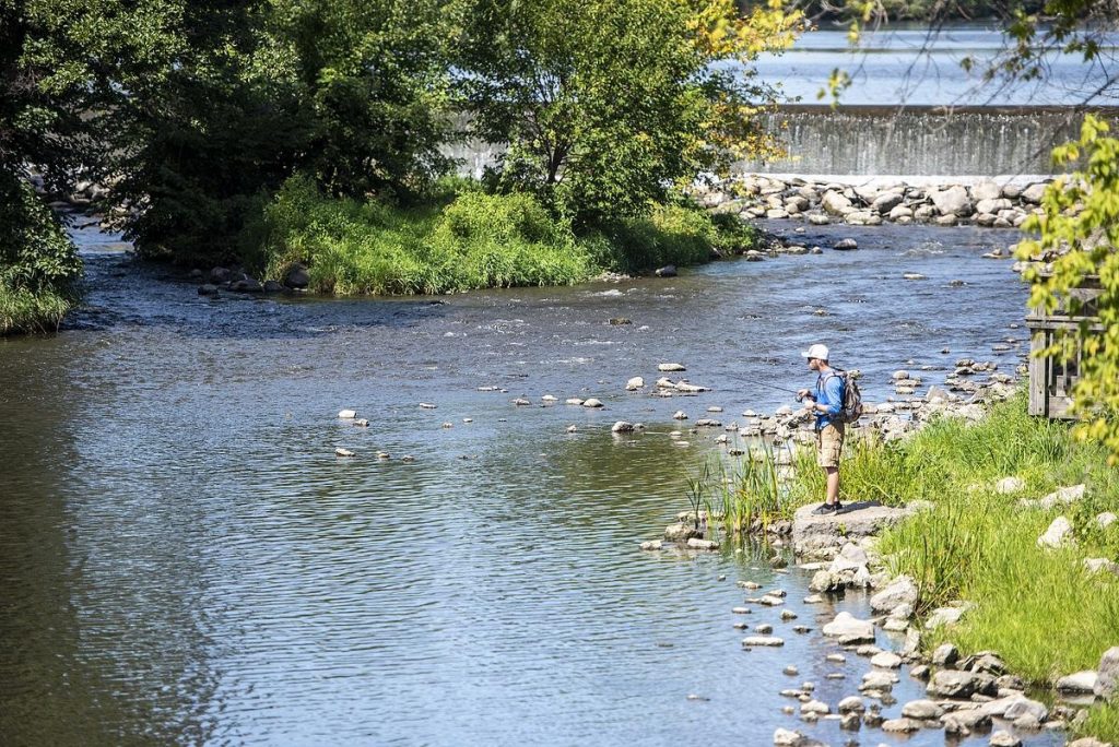 An angler casts a line near the Echo Lake Dam on Sept. 1, 2022, in Burlington, Wis. The Echo Lake Dam project tentatively received a grant for over $700,000 from the Knowles-Nelson Stewardship Fund for development of gathering spaces adjacent to the lake and got a $10 million earmark in the latest state budget. (Angela Major / WPR)