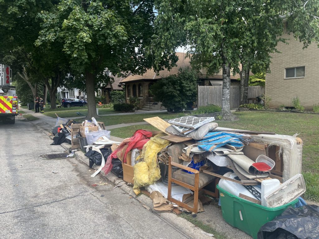 Discarded items line the street in West Allis, Wis. on Aug. 15, 2025 after recent storms and flooding. Corrinne Hess/WPR