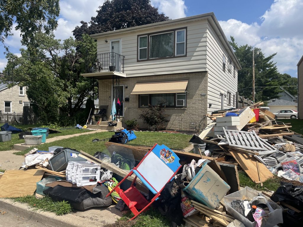 Occupants of homes in West Allis, Wis. on Aug. 15, 2025 are getting rid of items damaged from recent storms and flooding. Corrinne Hess/WPR