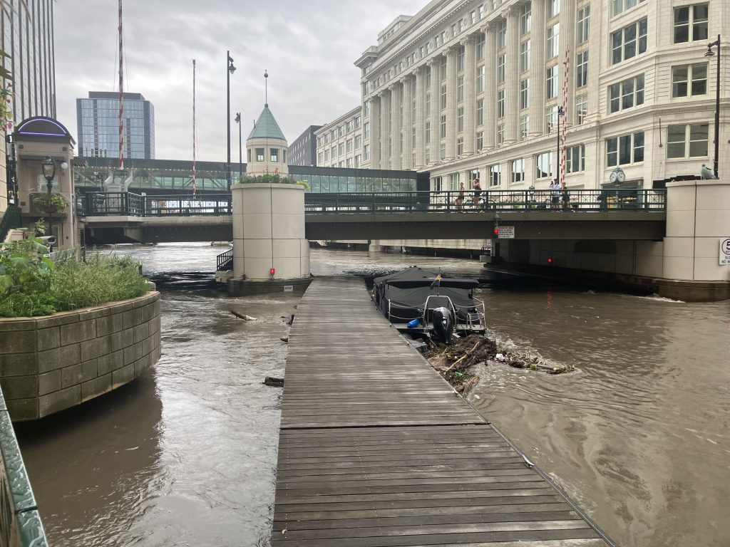 A boat and pier float down the Milwaukee River. Photo by Jonathan Ward.
