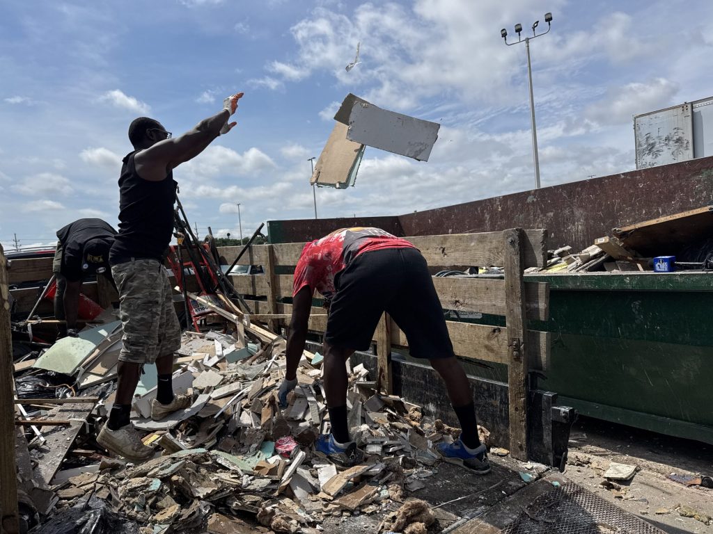 Milwaukee residents throw away items ruined by flooding at a drop-off center in the city on Monday, Aug. 11, 2025. Evan Casey/WPR