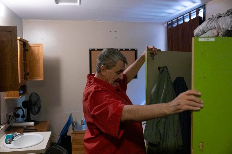 Randy Nelson, an Army veteran, looks through the dresser in his room, Monday, Aug. 25, 2025, at Klein Hall in Chippewa Falls, Wis. (Joe Timmerman / Wisconsin Watch)