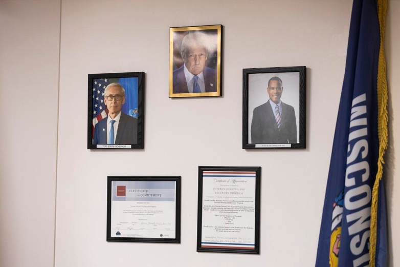 Official portraits of Gov. Tony Evers, President Donald Trump, and WVDA Secretary James Bond hang on the wall, Monday, Aug. 25, 2025, at Klein Hall in Chippewa Falls, Wis. (Joe Timmerman / Wisconsin Watch)