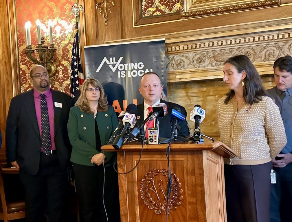 Rep. Scott Krug, R-Rome, at podium, and Rep. Lee Snodgrass, D-Appleton, right, announce competing legislative packages at an unusual joint press conference at the Wisconsin State Capitol in Madison, Wis., on Sept. 24, 2025. Anya van Wagtendonk/WPR