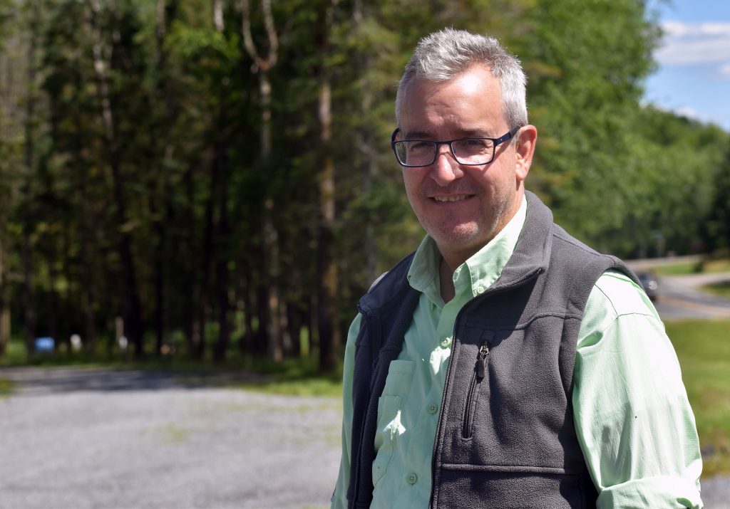 Steve Donohue, a director on the mining company’s board, stands outside the P-Town Saloon and Grill on July 17, 2025. It’s located nearby the site where Green Light Wisconsin is drilling for copper and gold in Taylor County. Danielle Kaeding/WPR
