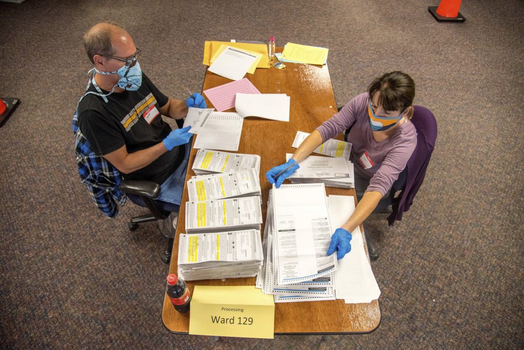 Election workers Jeff and Lori Lutzka, right, process absentee ballots at Milwaukee’s central count facility on Aug. 11, 2020. Will Cioci/Wisconsin Watch