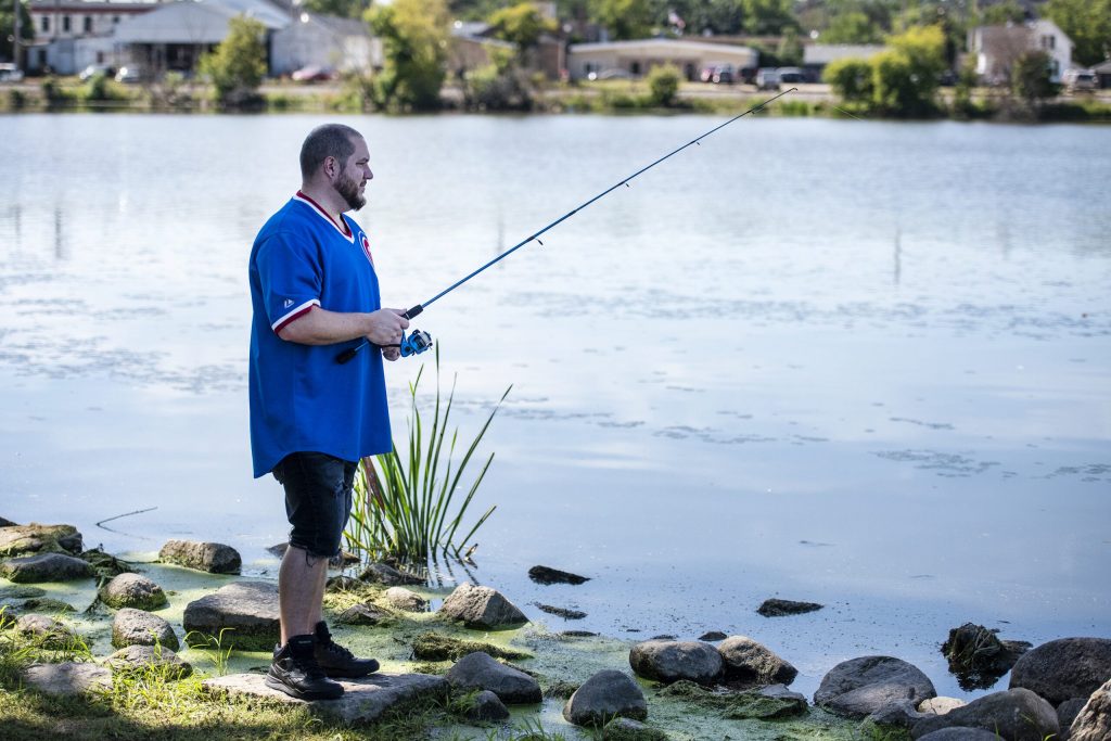 Burlington resident Benjamin Ness fishes near the Echo Lake Dam on Thursday, Sept. 1, 2022, in Burlington, Wis. Angela Major/WPR