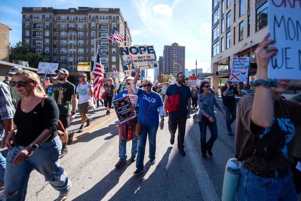 Protesters march in opposition to President Trump on Saturday, Oct. 18, 2025, at Cathedral Square Park in Milwaukee, Wis. Angela Major/WPR