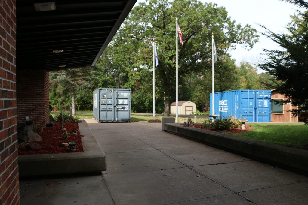 Two shipping containers sit next to a former veteran housing and recovery program facility in Chippewa Falls. Amid an ongoing deficit and a political impasse over a request for an additional $1.9 million, the facility and another veteran housing program in Green Bay officially closed Sept. 30. Rich Kremer/WPR