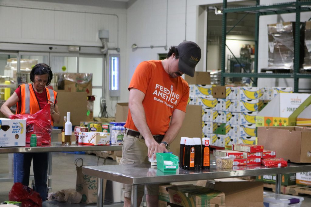Volunteers pack food boxes at Feeding America Eastern Wisconsin, 1700 W. Fond du Lac Ave. Photo taken Aug. 12, 2025 by Sophie Bolich.