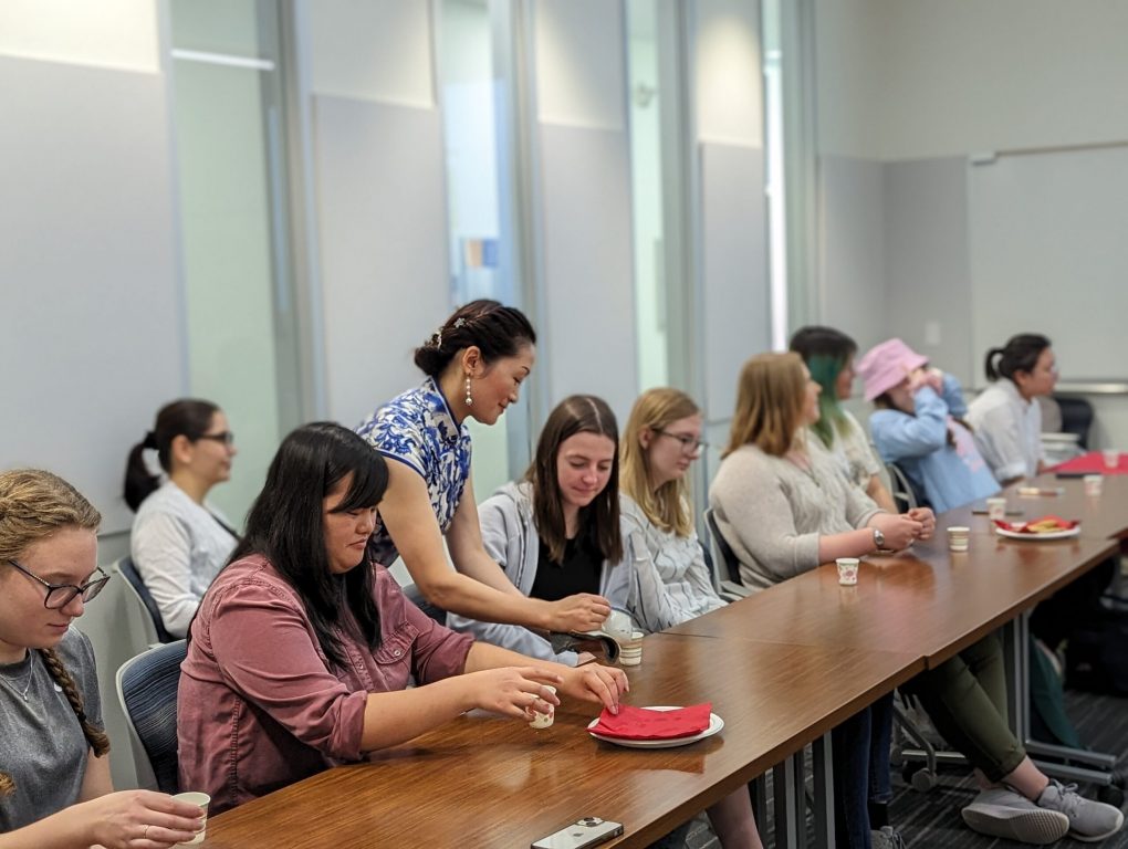 Caiyun Zhou, standing, serves tea to students at UW-Eau Claire as part of a traditional Chinese tea ceremony. Photo courtesy of Kaishan Kong