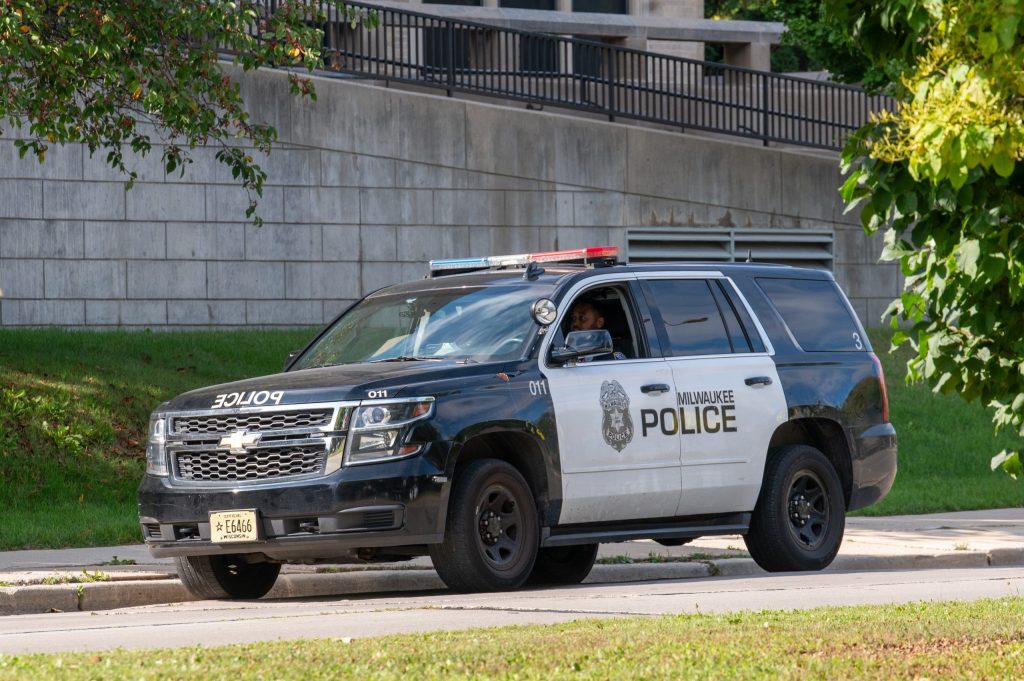 A Milwaukee Police Department patrol vehicle is parked in front of Washington High School of Information Technology. Officers were assigned to MPS in March after a court order required that the district and City of Milwaukee comply with Wisconsin Act 12, a state law mandating the district have at least 25 police officers stationed at schools. (Photo by Jonathan Aguilar / Milwaukee Neighborhood News Service / CatchLight Local)