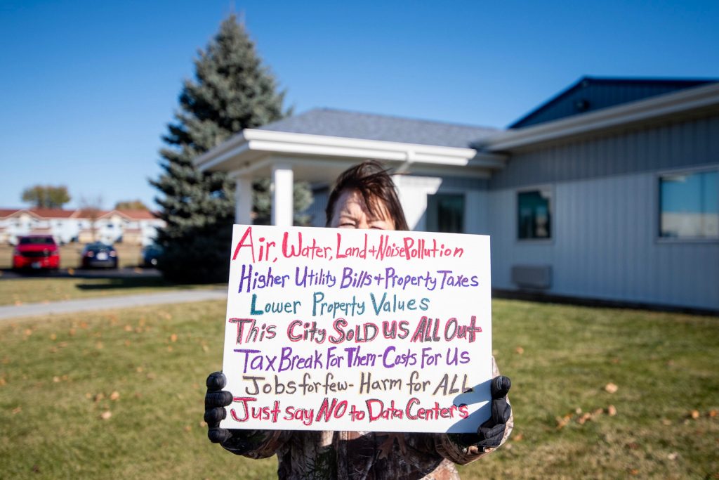 A protester holds a sign outside of a Meta data center announcement Wednesday, Nov. 12, 2025, in Beaver Dam, Wis. Angela Major/WPR