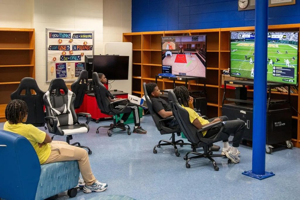 Youth hang out and play video games in the Twilight Center game room at North Division High School. (Photo by Jonathan Aguilar / Milwaukee Neighborhood News Service / CatchLight Local)
