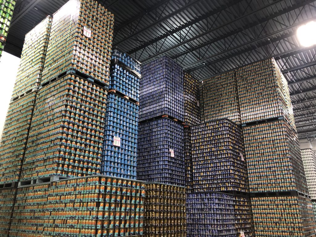 Stacks of empty cans at Good City Brewing's Century City I space in 2022. Photo by Jeramey Jannene.