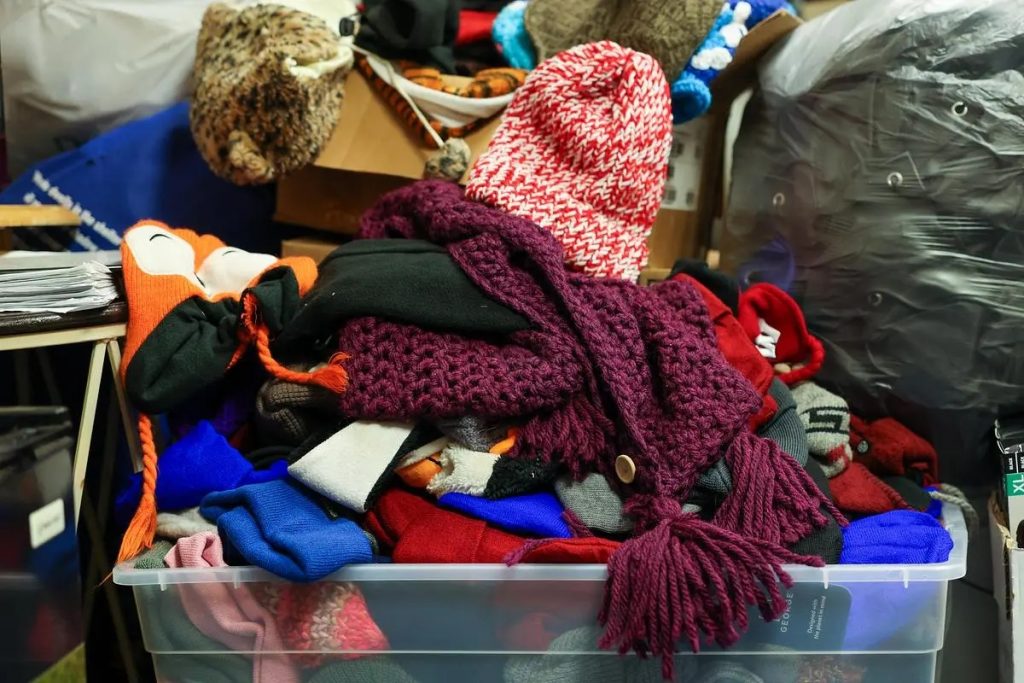 Winter accessories sit in a bin ready to be distributed at Repairers of the Breach. Photo from NNS.