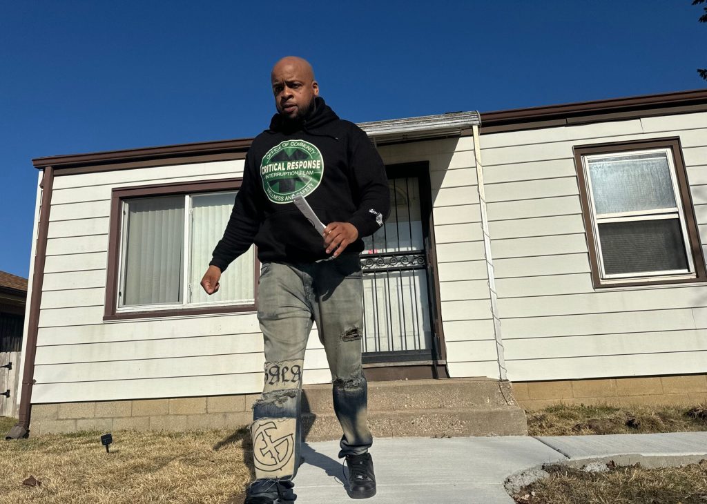 Stephen Hopkins with Milwaukee’s Critical Response Team hands out brochures following a recent shooting on the city’s north side. Evan Casey/WPR