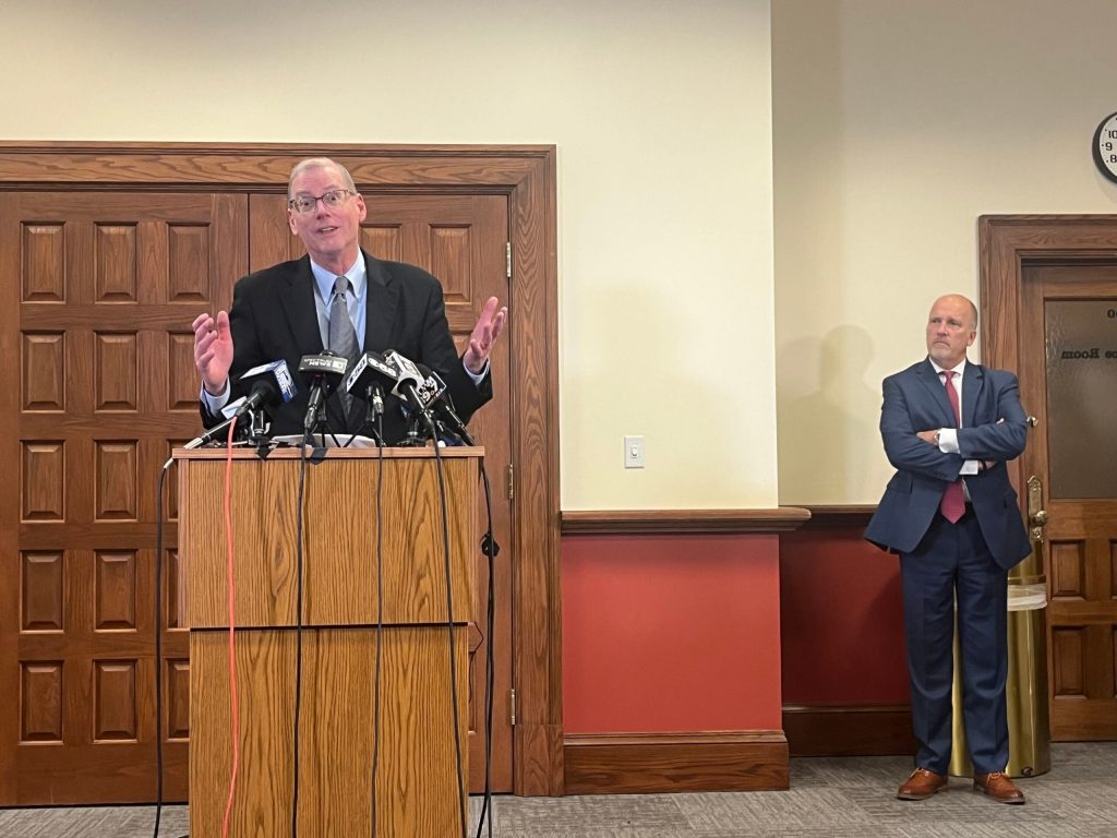 Steve Biskupic, the lead defense attorney for Judge Hannah Dugan, addresses reporters following the verdict in Dugan’s jury trial on Dec. 18, 2025. Brad Schimel, the interim U.S. Attorney for the Eastern District of Wisconsin, watches in the background. Corrinne Hess/WPR