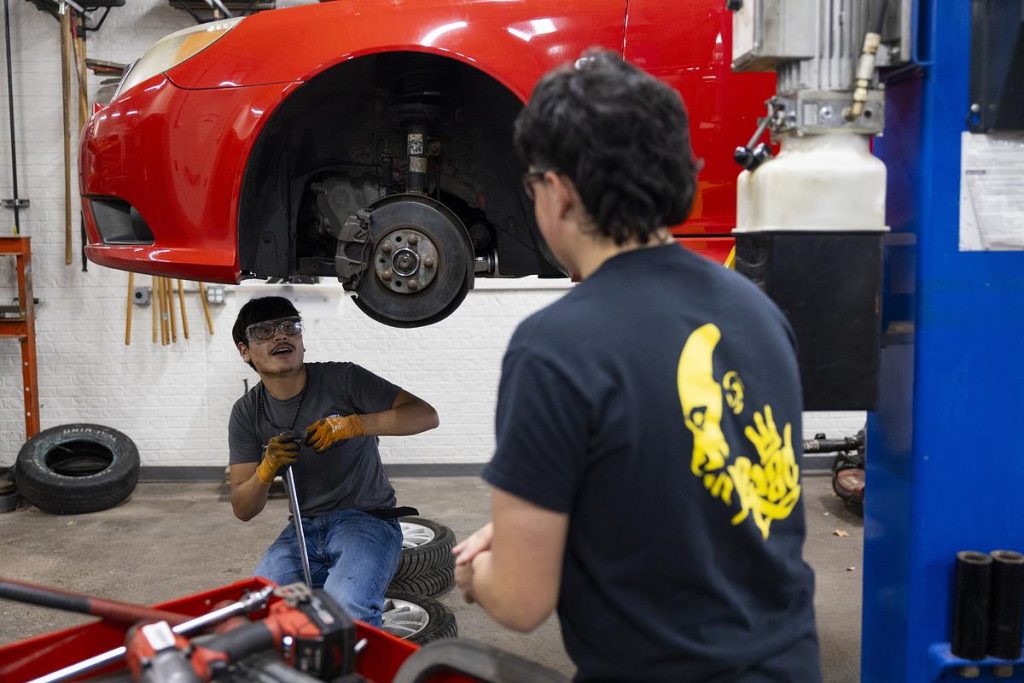 Oscar Haro Rodriguéz, left, and José Ruiz work on a car during an Auto 3 dual enrollment class on Nov. 12, 2025. (Joe Timmerman / Wisconsin Watch)