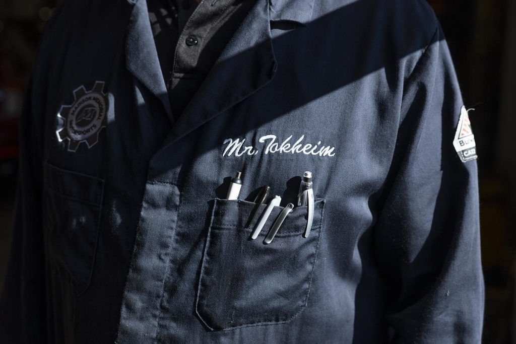 Miles Tokheim, a technology and engineering teacher, poses for a portrait during an Auto 3 dual enrollment class, Wednesday, Nov. 12, 2025, at Vel Phillips Memorial High School in Madison, Wis. (Joe Timmerman / Wisconsin Watch)