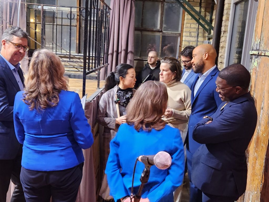 The Democratic gubernatorial field prepares to take the stage Wednesday. Left to Right: Joel Brennan, Kelda Roys, Francesca Hong, Sara Rodriguez, Missy Huges, Mandela Barnes and David Crowley. (Photo by Erik Gunn/Wisconsin Examiner)