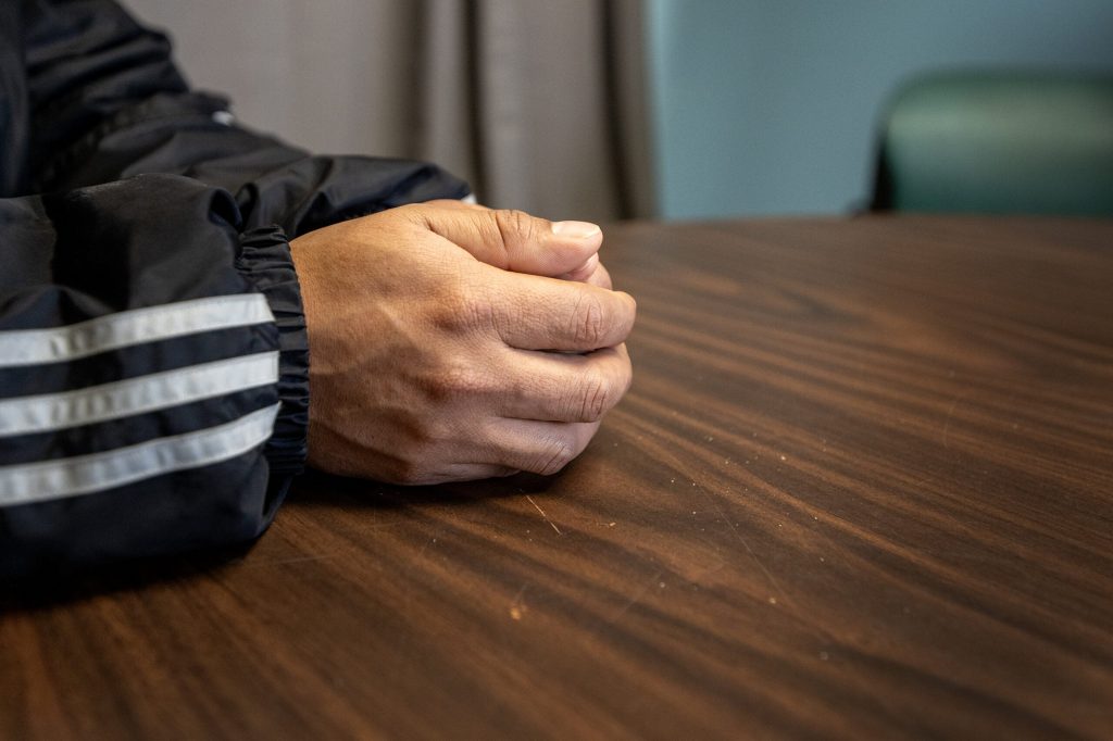 Juan Sandovar’s hands are clasped as he speaks about his experience Wednesday, Jan. 7, 2026, at the Community Space in Whitewater, Wis. Angela Major/WPR