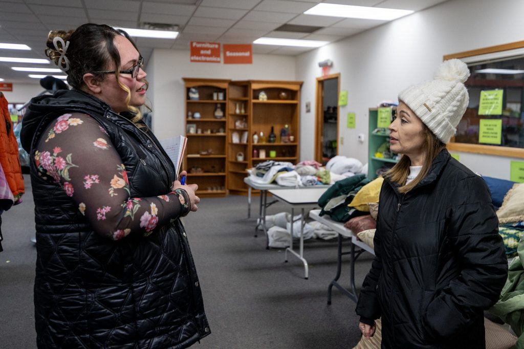 Volunteer Soledad Alvarez, left, speaks to someone browsing items at the Community Space on Wednesday, Jan. 7, 2026, in Whitewater, Wis. Angela Major/WPR