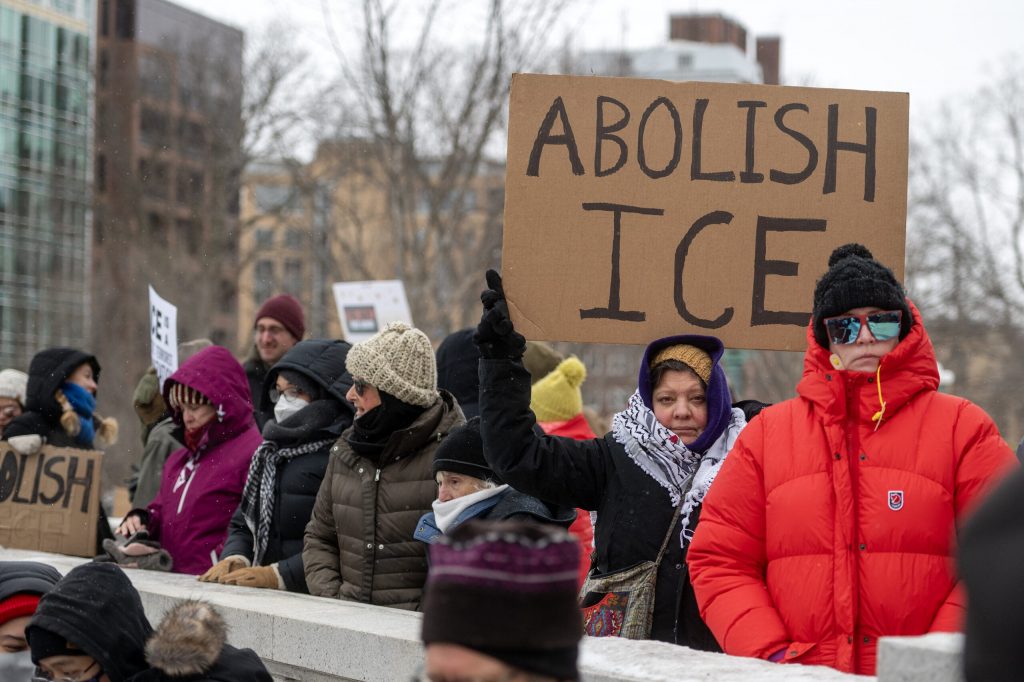 A protester holds a sign Sunday, Jan. 25, 2026, in Madison, Wis. The protest came after a Border Patrol agent shot and killed Alex Pretti in Minneapolis the day before. Angela Major/WPR