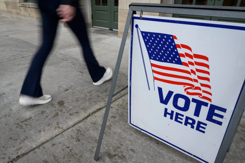 On Election Day, April 4, 2023, pedestrians walk past a “Vote Here” sign at the entrance to the Memorial Union at the University of Wisconsin–Madison, one of several official polling places for UW–Madison students living on campus. Althea Dotzour/UW–Madison