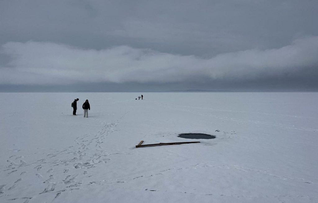 Locals walk on a mostly frozen Lake Mendota on March 7, 2025. (Jess Miller for Wisconsin Watch)