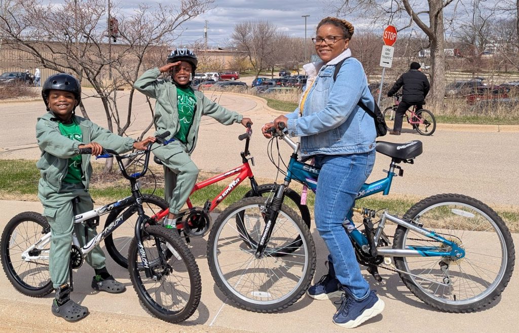 Mom and twin boys receiving bikes at the 2025 Bike Giveaway event; photo by Kevin Anderson.