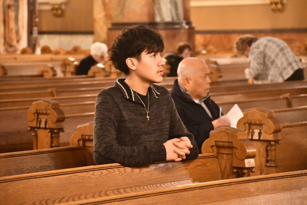 Luis Flores prays before mass on Feb. 20 at the Basilica of Saint Josaphat, awaiting the unveiling of the life-size statue of Our Lady of Guadalupe. Mackenzie Krumme/WPR