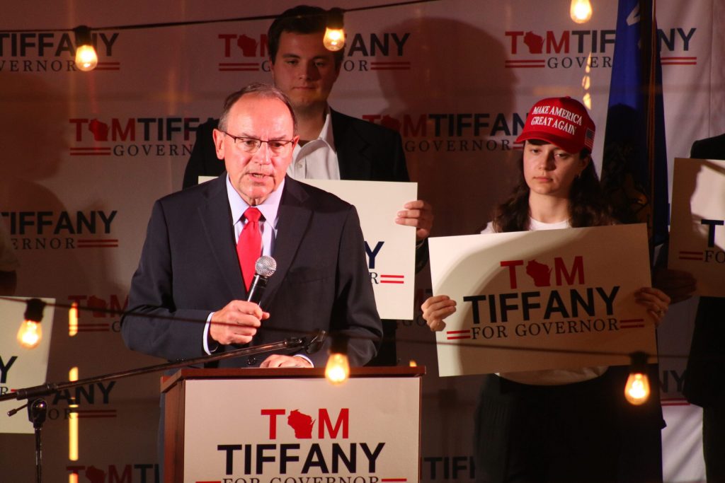 Republican Congressman Tom Tiffany launches his campaign for Wisconsin governor at a renovated barn near Wausau on Sept. 24, 2025. UW-River Falls College Republican member Isa Blett stands on stage behind him. Rich Kremer/WPR