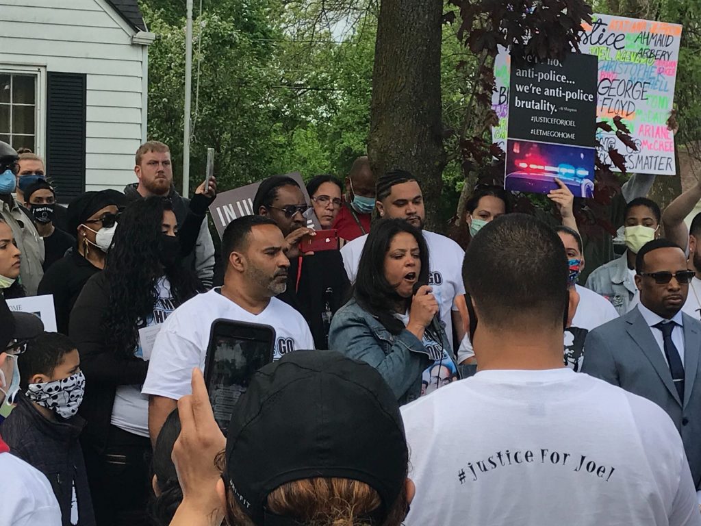 Member of Joel Acevedo’s family speak to protestors gathered by the house of Michael Mattioli, the Milwaukee police officer facing charges in Acevedo’s death, on Friday, May 29. Madeline Fox/WPR