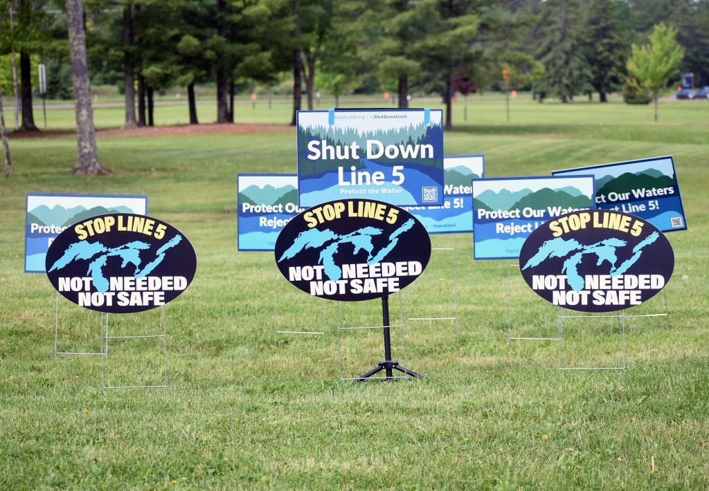 Signs read “Shut Down Line 5” and “Stop Line 5” outside the site of a public hearing in Ashland on a draft environmental assessment of Enbridge’s proposal to reroute the pipeline on June 4, 2024. Danielle Kaeding/WPR