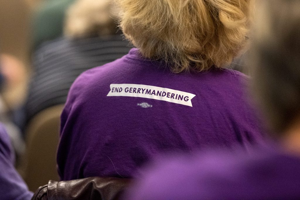 An attendee sits in the crowd and listens as state legislators discuss redistricting during a hearing Thursday, Oct. 28, 2021, in at the Wisconsin State Capitol in Madison, Wis. Angela Major/WPR