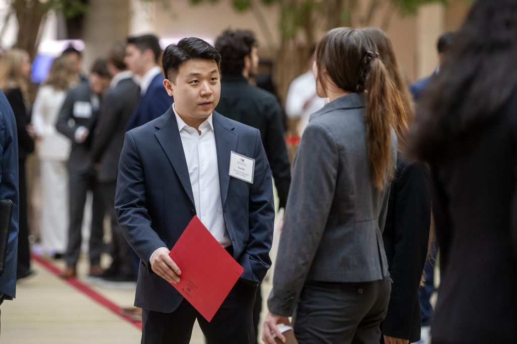 Paul Oh, a senior business administration major at University of Washington Bothell, speaks to another student during a networking event Friday, March 20, 2026, at UW-Madison in Madison, Wis. Angela Major/WPR