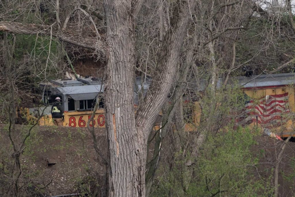 Workers attend to a train derailed by severe storms Saturday, April 18, 2026, in Janesville, Wis. Angela Major/WPR