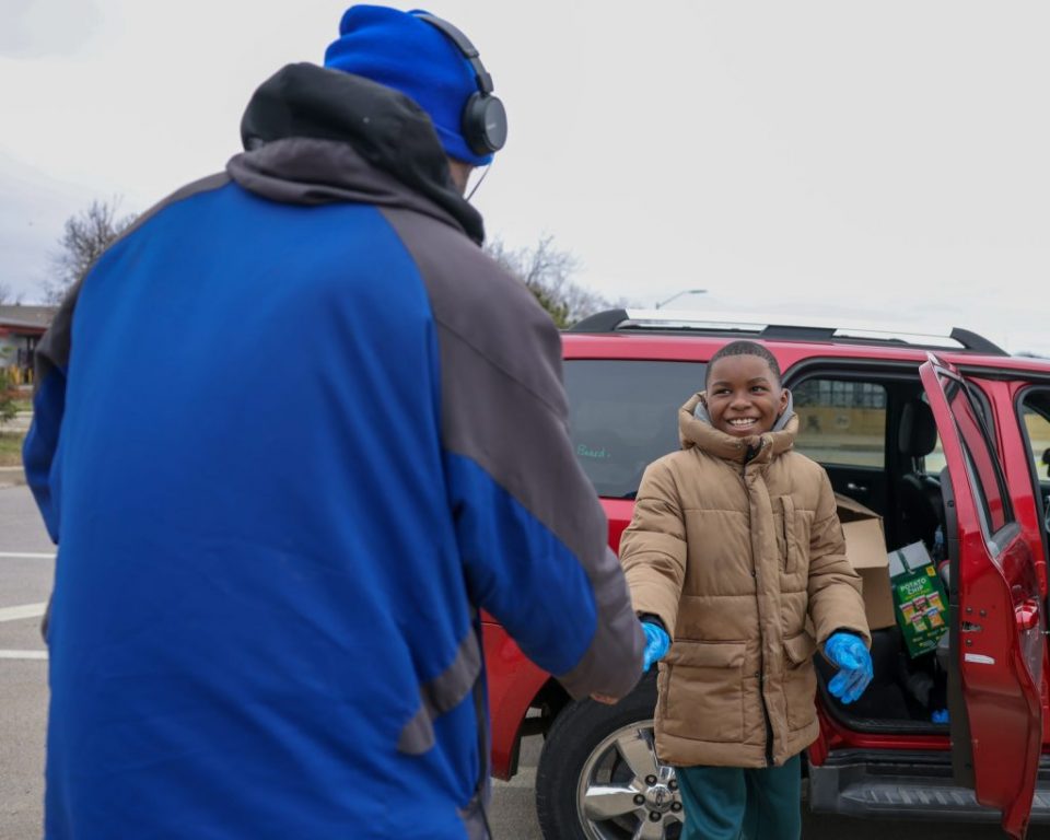 Carter Wilkins shakes hands with a man after giving him a homemade lunch and hygiene products on April 3. (Photo by Jonathan Aguilar / Milwaukee Neighborhood News Service / CatchLight Local)