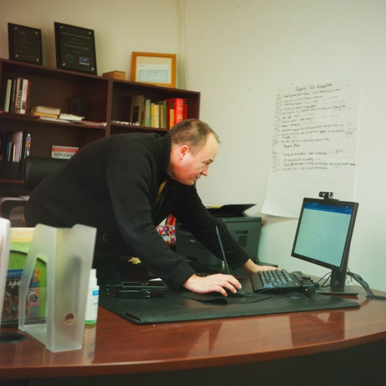 Andrew Trumbull, co-founder and administrative director at the Burmese Rohingya Community of Wisconsin, works on his computer in his office, Jan. 19, 2026, in Milwaukee.