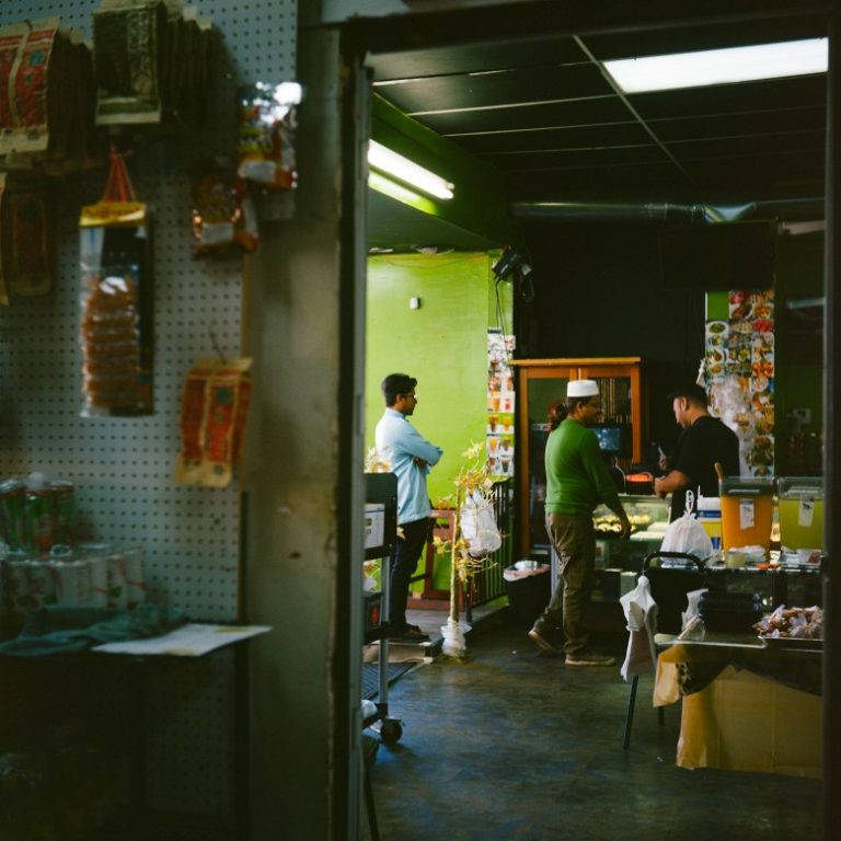 Mohamed Ibrahim, owner of Khan Aseya Restaurant, known as “Mom’s Kitchen,” center, serves takeout meals during the first day of Ramadan on Feb. 18, 2026, in Milwaukee.