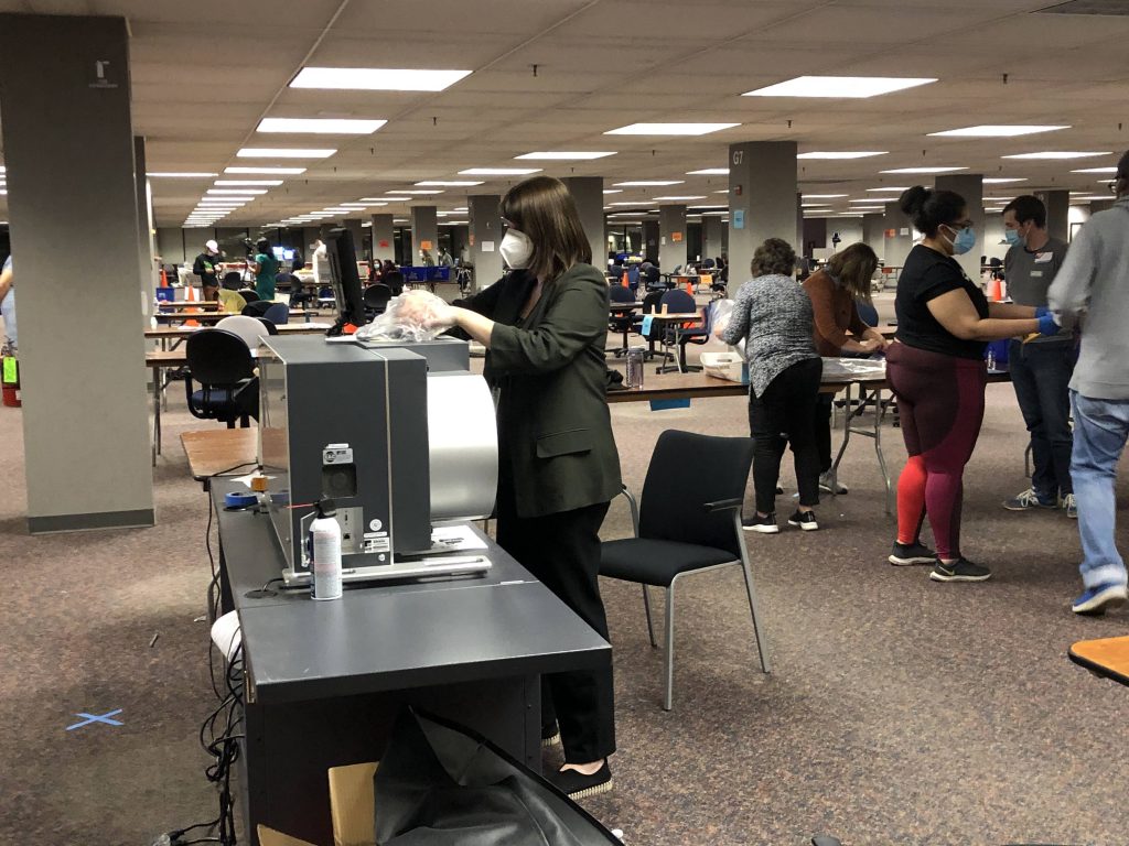 Claire Woodall exports absentee ballots from a tabulator on election night 2020. Photo by Jeramey Jannene.