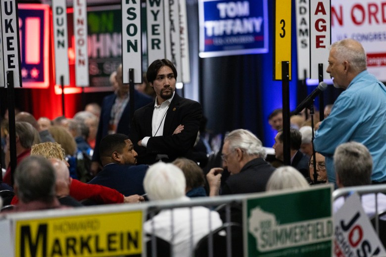 Republican Party of Milwaukee County Chairman Hilario Deleon, left, stands on the convention floor during the Republican Party of Wisconsin convention on May 17, 2025, at the Central Wisconsin Convention & Expo Center in Rothschild, Wis. (Joe Timmerman / Wisconsin Watch)